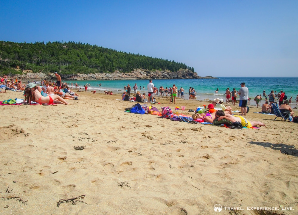 People sunbathing on Sand Beach, top Acadia National Park attractions