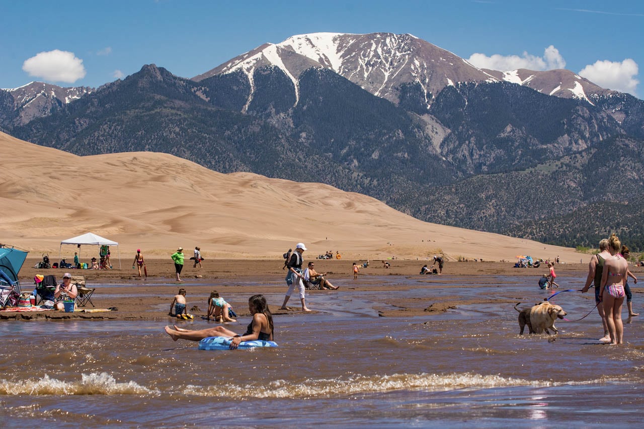 People and dogs in Medano Creek, Great Sand Dunes National Park, Colorado