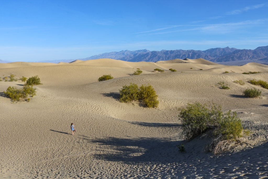 Mesquite Flat Sand Dunes hiker, Death Valley National Park, one of several warm national parks to escape winter weather