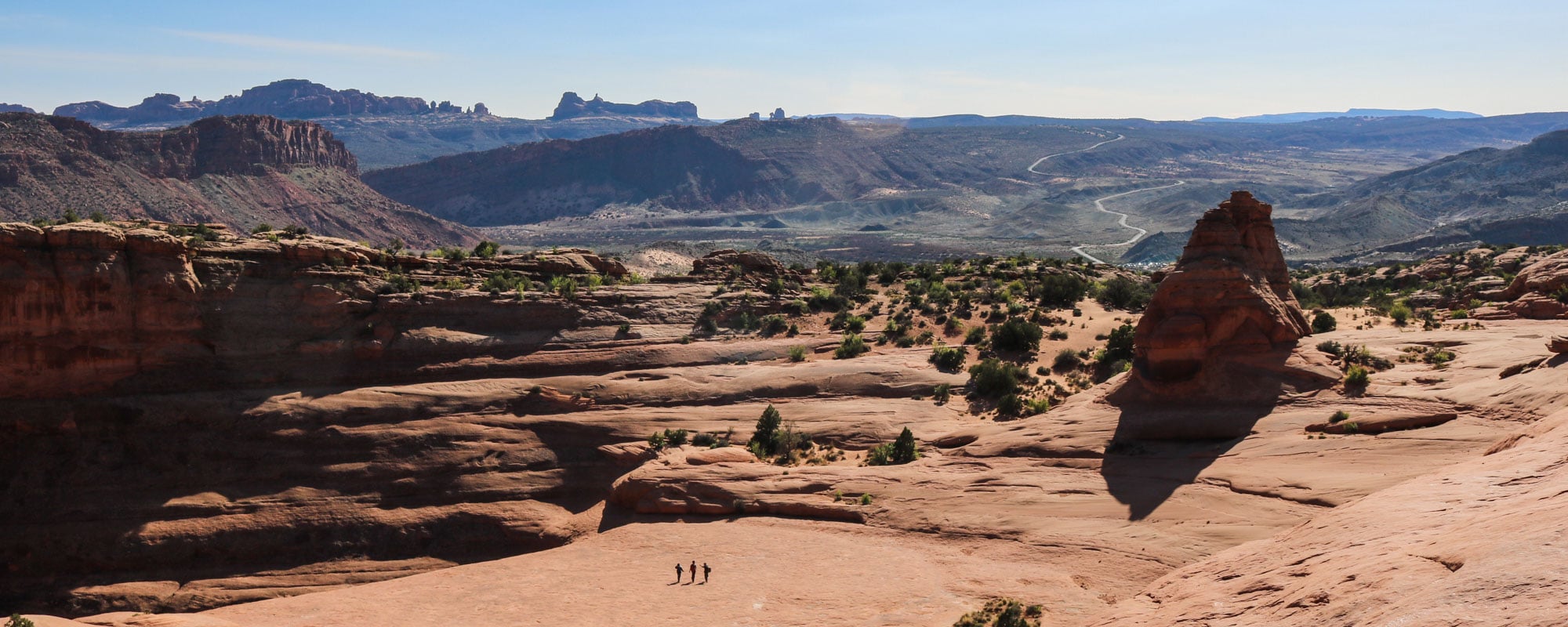 Three hikers in Arches National Park, Utah banner