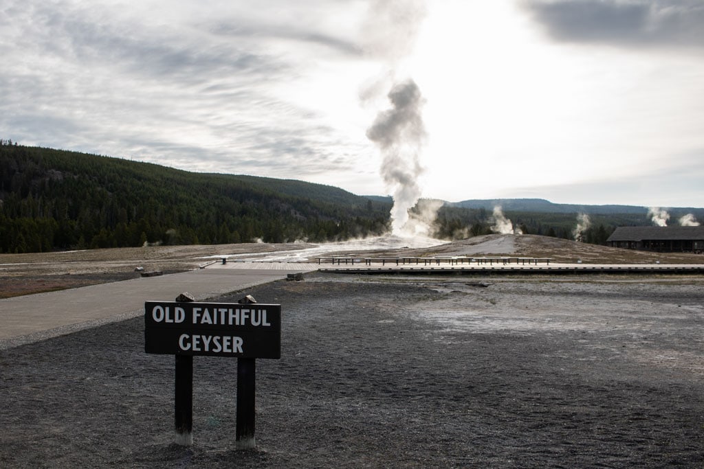 Old Faithful Geyser sign at Upper Geyser Basin, one of the busiest and best places to visit in Yellowstone National Park