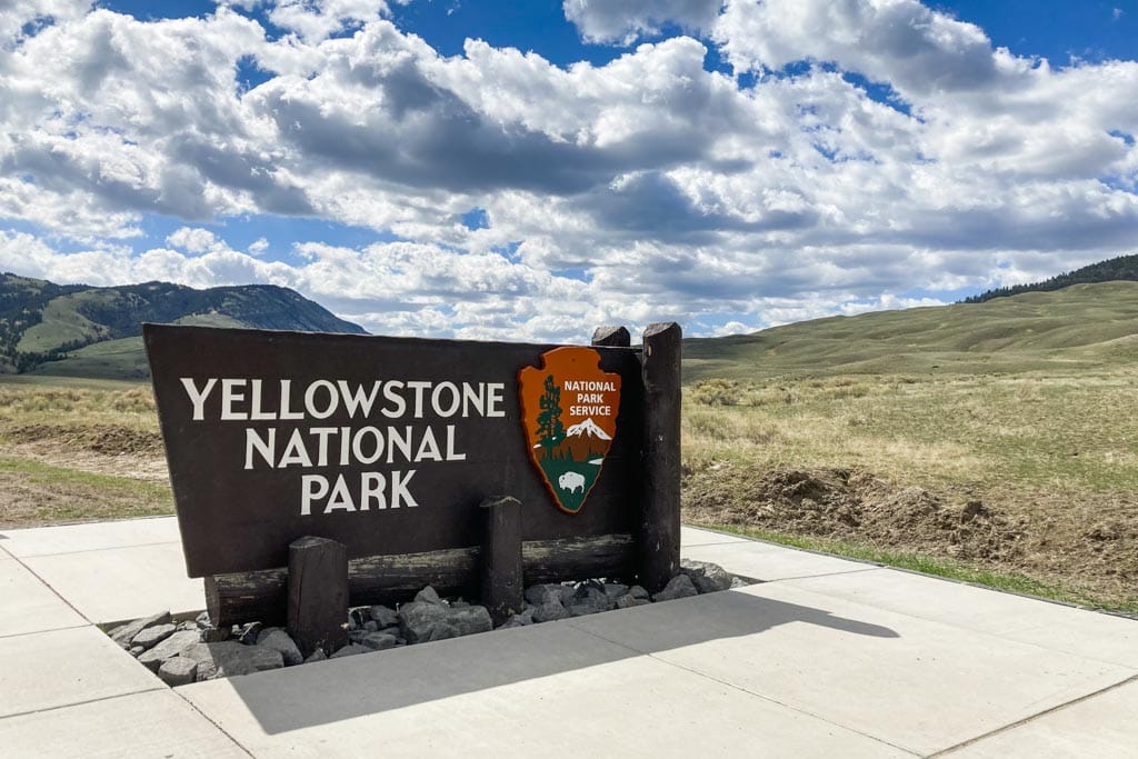 Yellowstone National Park sign in Gardiner, Montana, one of the parks to explore on a road trip to the northern Rockies national parks