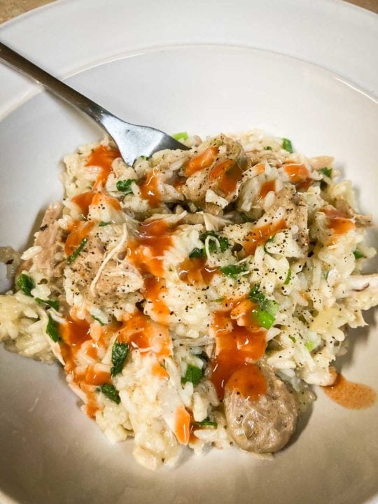 Congaree National Park inspired South Carolina chicken bog with hot sauce in bowl with fork