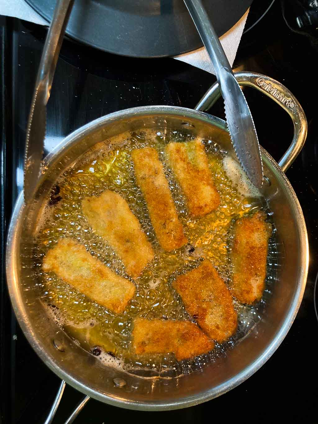 Fish tacos frying in pan on stove