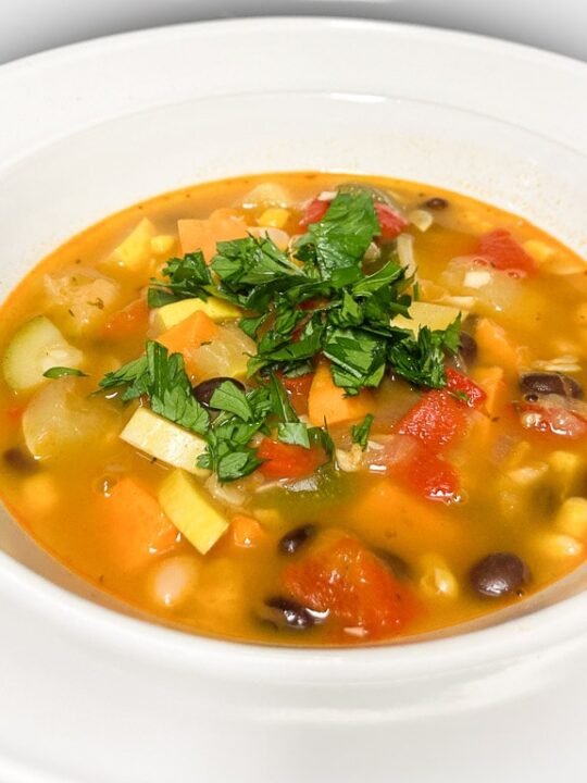 Three sisters soup recipe with corn, beans and squash in white bowl