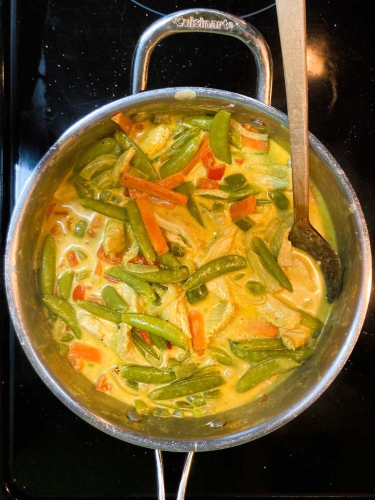 Curry chicken ingredients in pan on stovetop