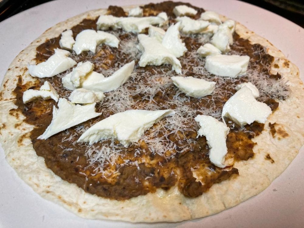 Tortilla pizza with black bean spread, mozzarella and parmesan