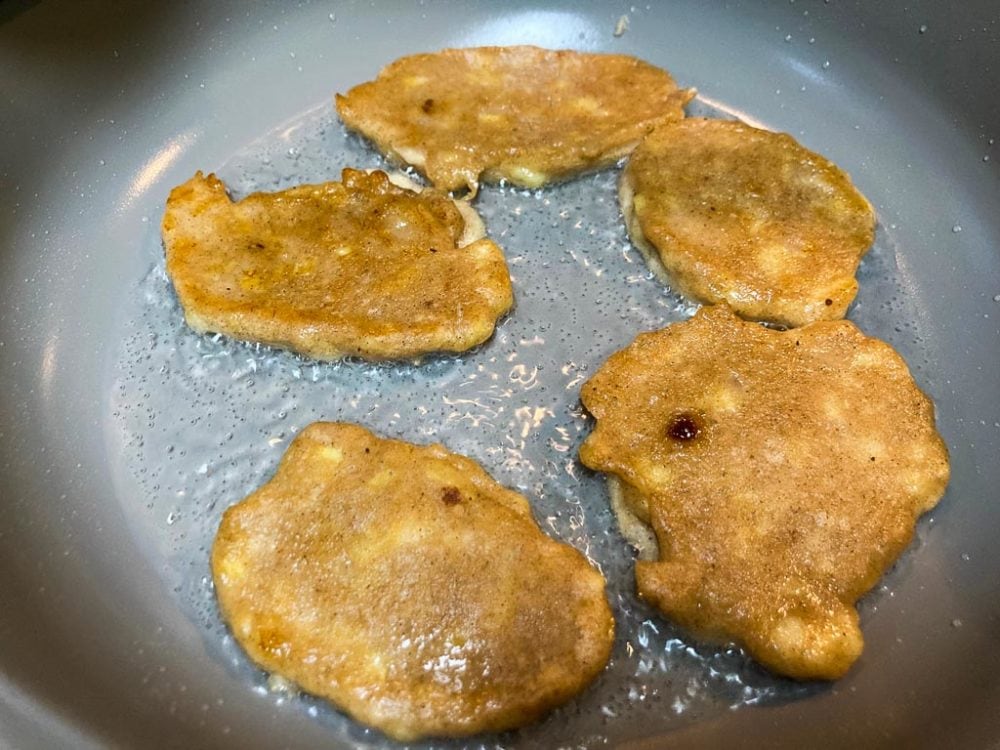 Banana fritters frying in coconut oil