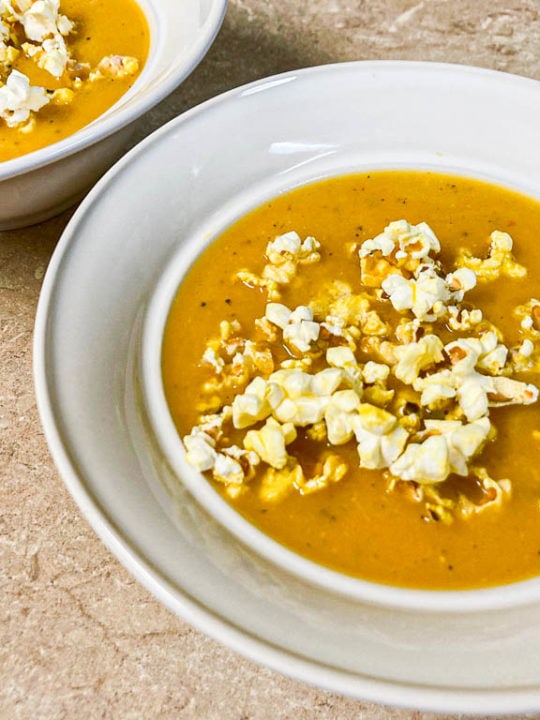 Butternut squash soup with popcorn in bowl