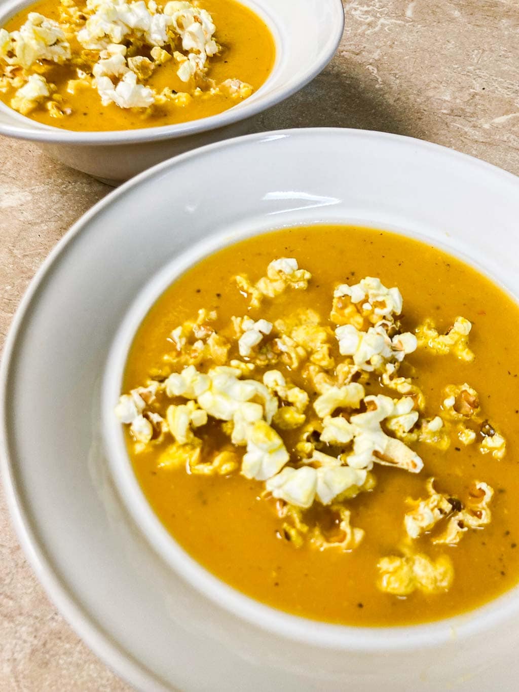 Butternut squash soup with popcorn in bowls