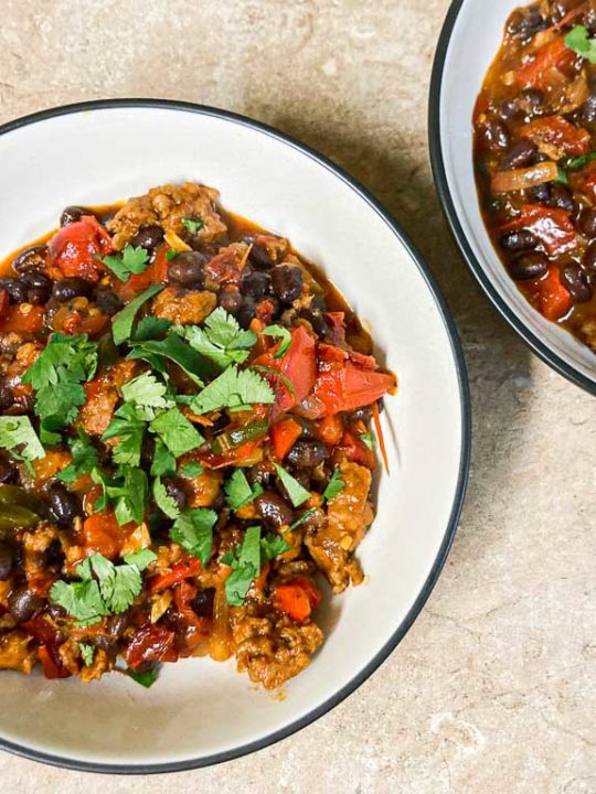 Chorizo, black beans and roasted bell pepper skillet dish in bowls
