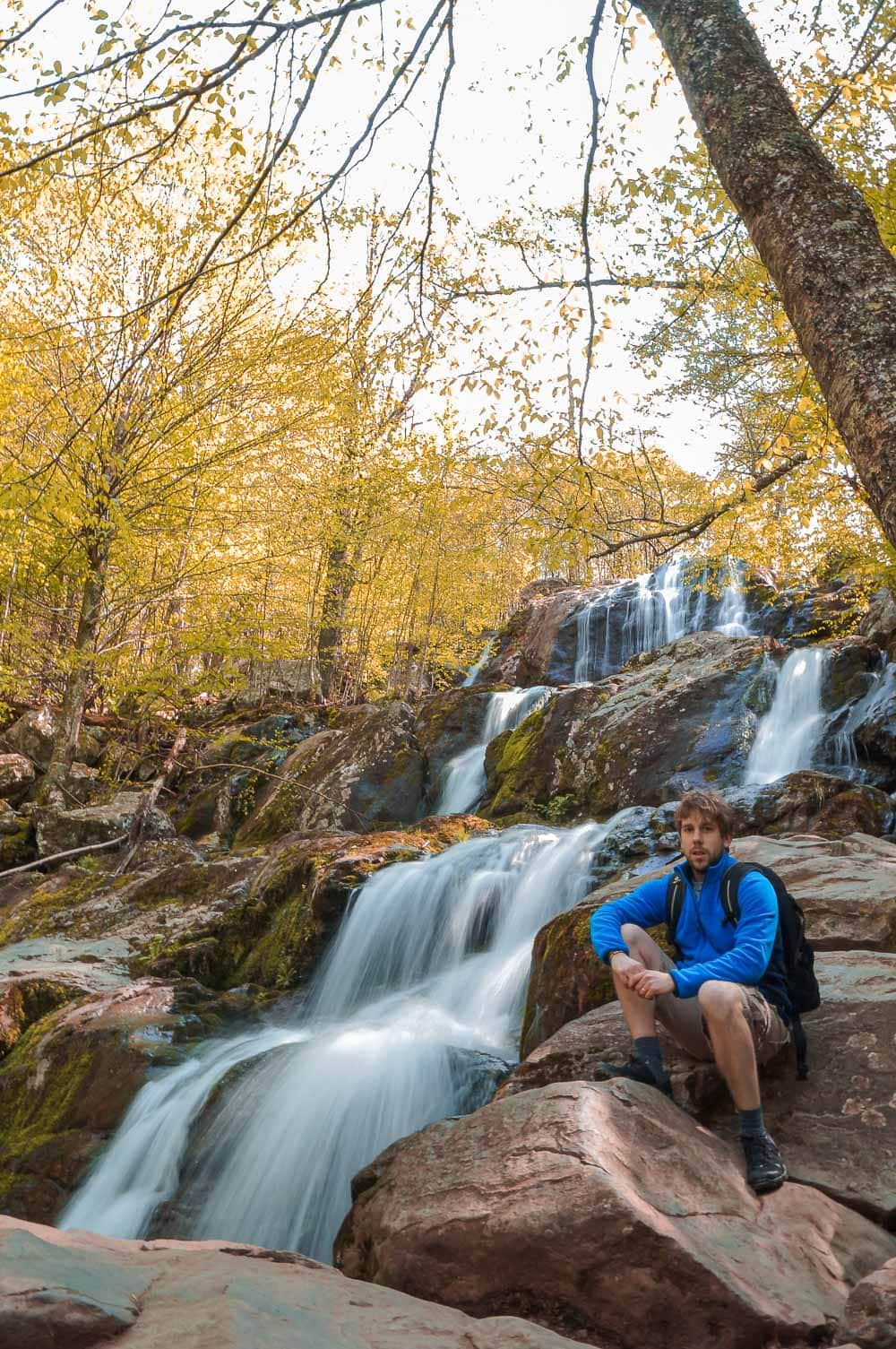 Hiker at Dark Hollow Falls in fall in Shenandoah National Park, Virginia