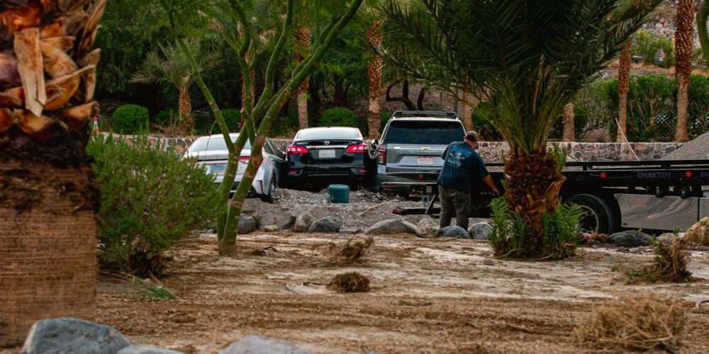 Three cars at the Inn at Death Valley pushed together by flash floods being towed, Death Valley National Park - Photo Credit NPS K. McCraren