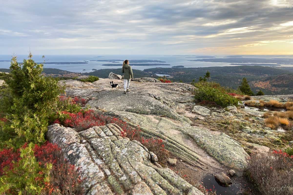 Pemetic Mountain hiker with dog in Acadia National Park, Maine