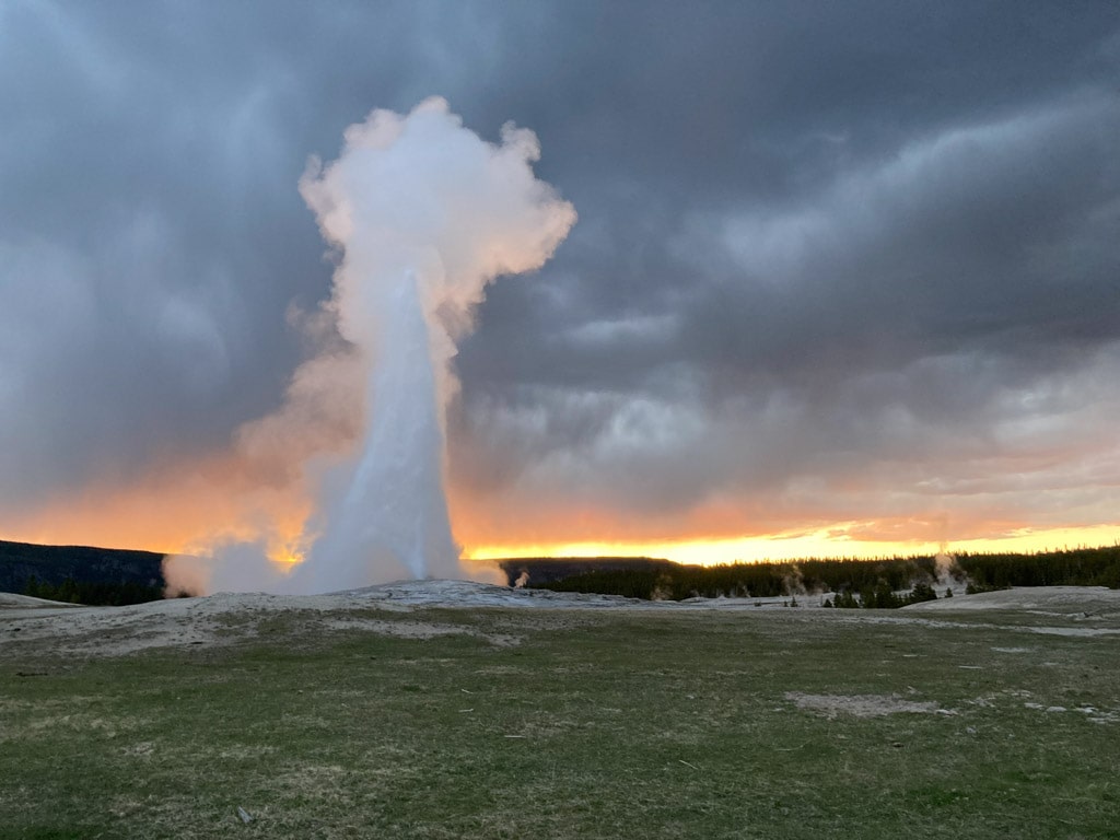 Old Faithful eruption at sunset in Yellowstone National Park