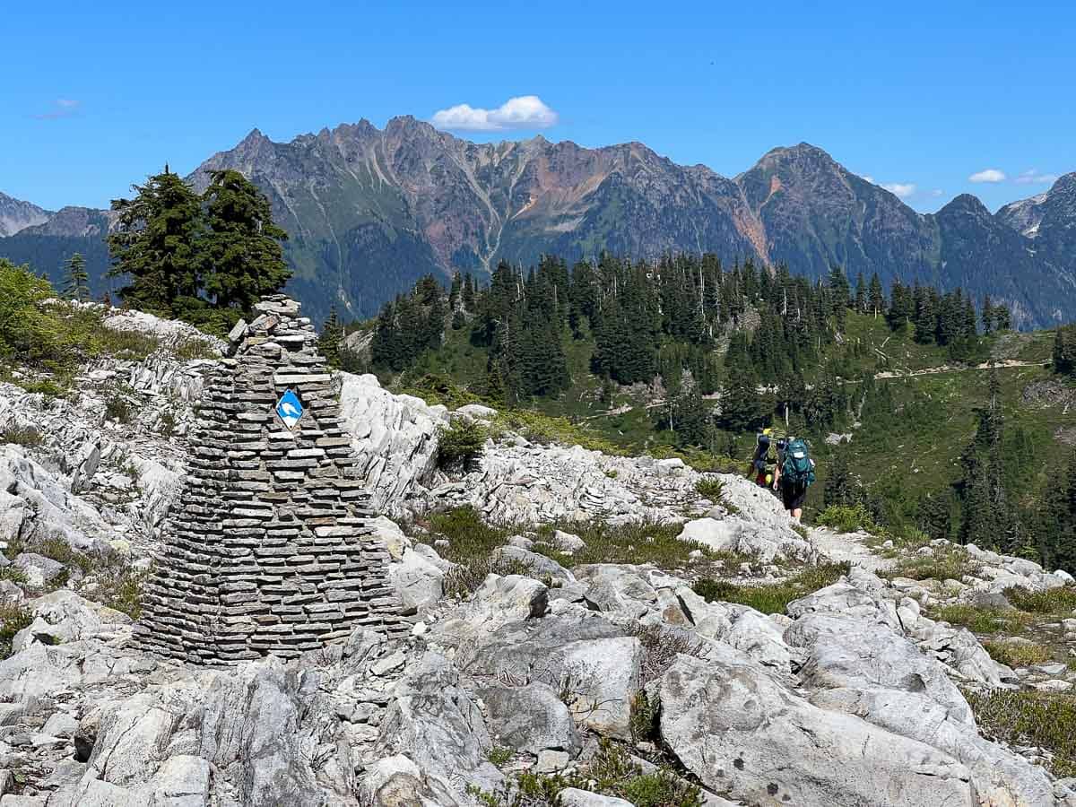 Cairn and backpackers on the Upper Wild Goose Trail, Mount Baker-Snoqualmie National Forest