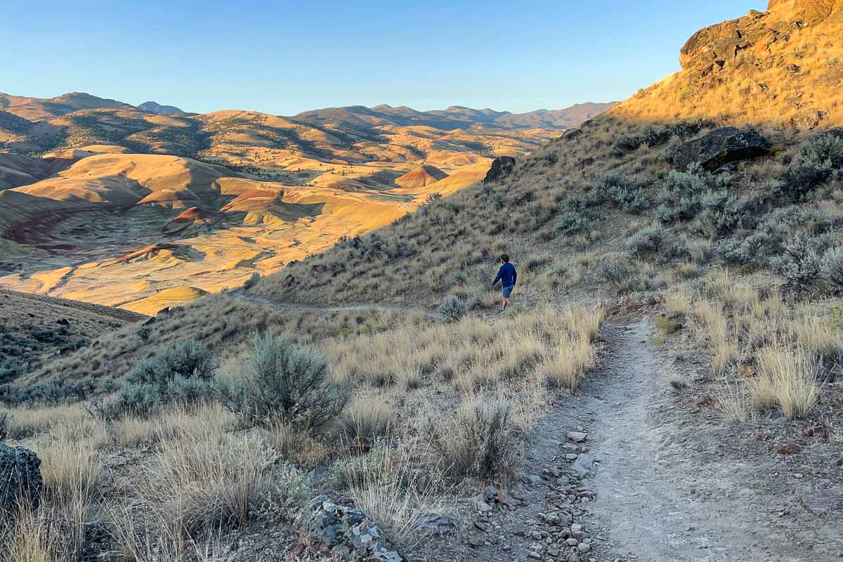 Hiker on the Carroll Rim Trail at the Painted Hills in John Day Fossil Beds National Monument, Oregon