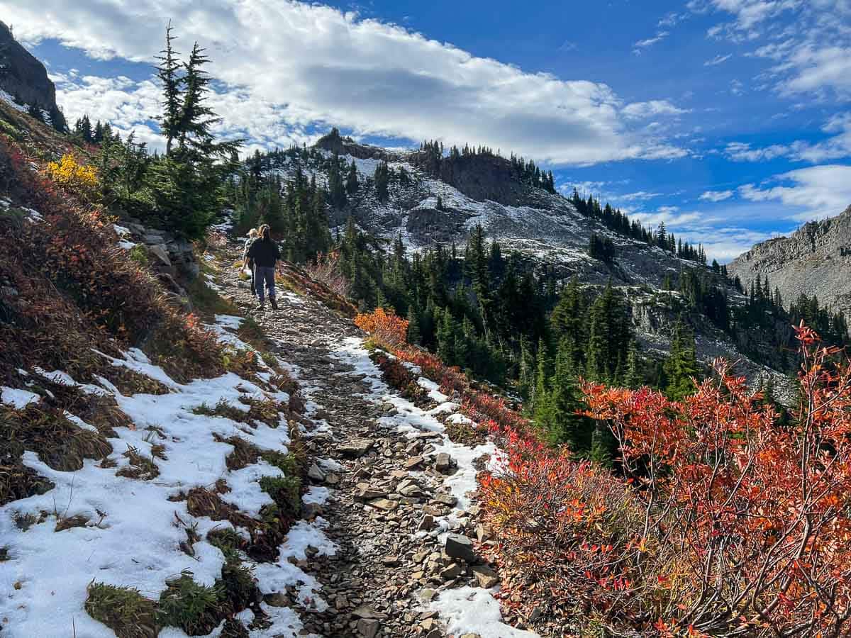 Hikers on the Pinnacle Peak Trail amid fall colors and snow, Mount Rainier National Park, Washington