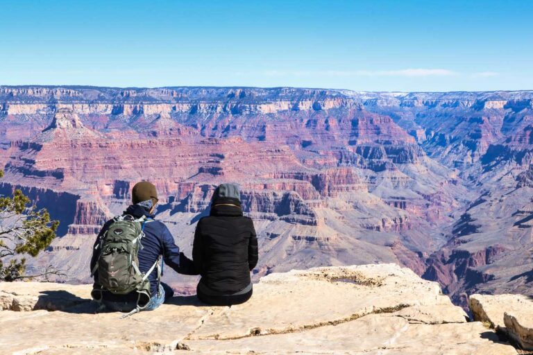 Couple holding hands while enjoying spectacular views in Grand Canyon National Park